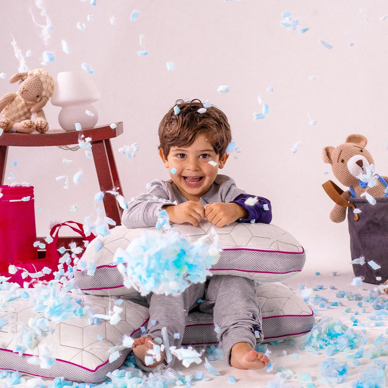 Criança brincando com travesseiros IWS Snow Kids e flocos de memory foam