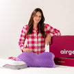 Mulher com o travesseiro IWS Airgelly 2.0 no colo, ao lado da embalagem