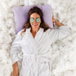 Mulher relaxando com a cabeça apoiada no travesseiro IWS Skin durante o skincare