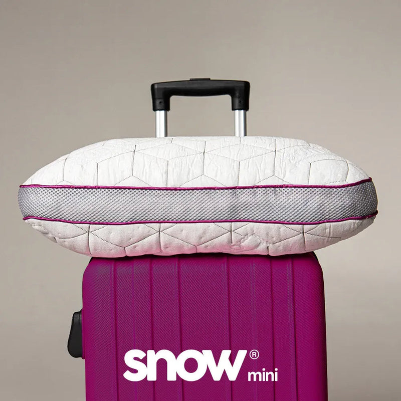 Travesseiro de viagem IWS Snow Mini sobre uma mala