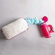 Travesseiro IWS Snow Mini ao lado da embalagem, com os flocos de memory foam